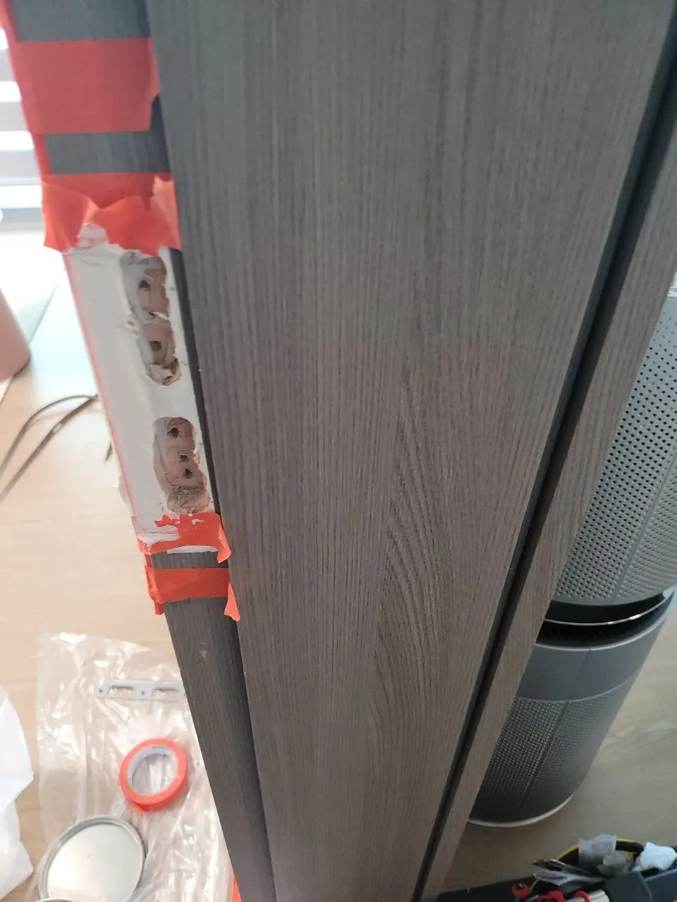 붉은 테이프로 둘레를 가린 문틀 옆면의 퍼티 작업 자리