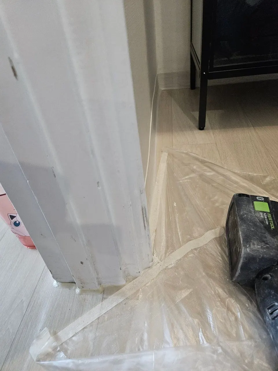 바닥과 벽 아래쪽에 비닐과 테이프로 보양한 문틀 하단