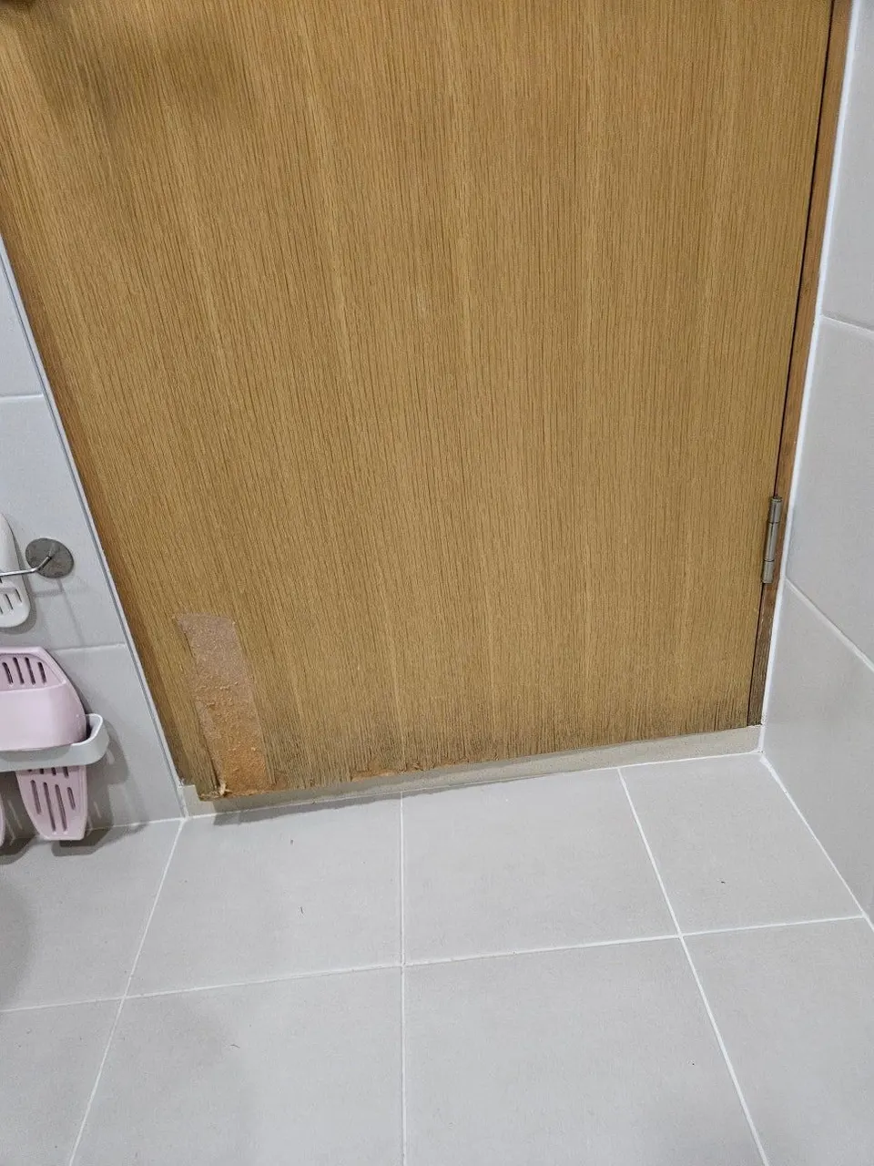욕실문 하단이 물을 먹어 어둡게 변하고 시트지가 들뜬 복원 전 모습