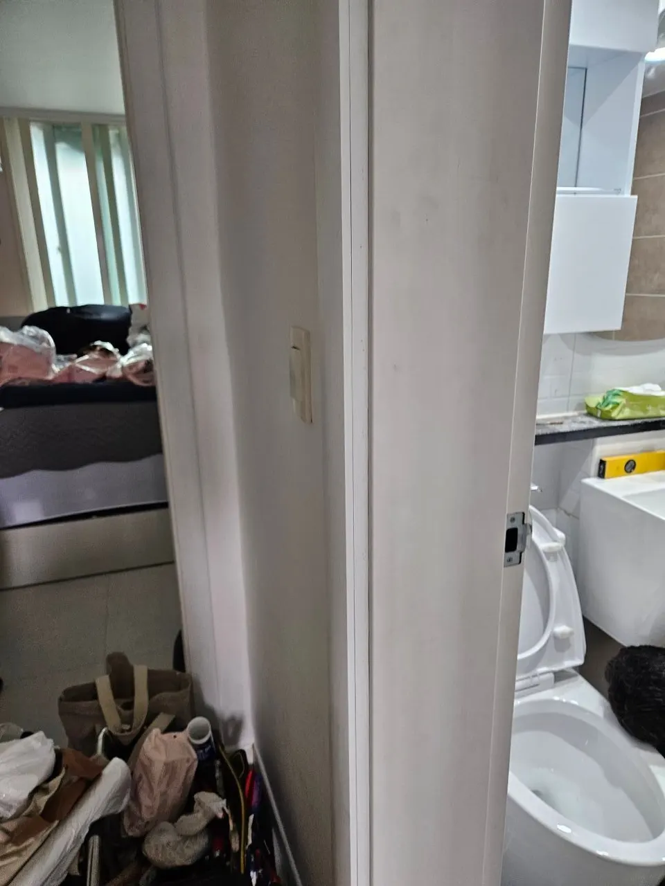 욕실 변기 옆에서 분리한 문과 문틀 옆면