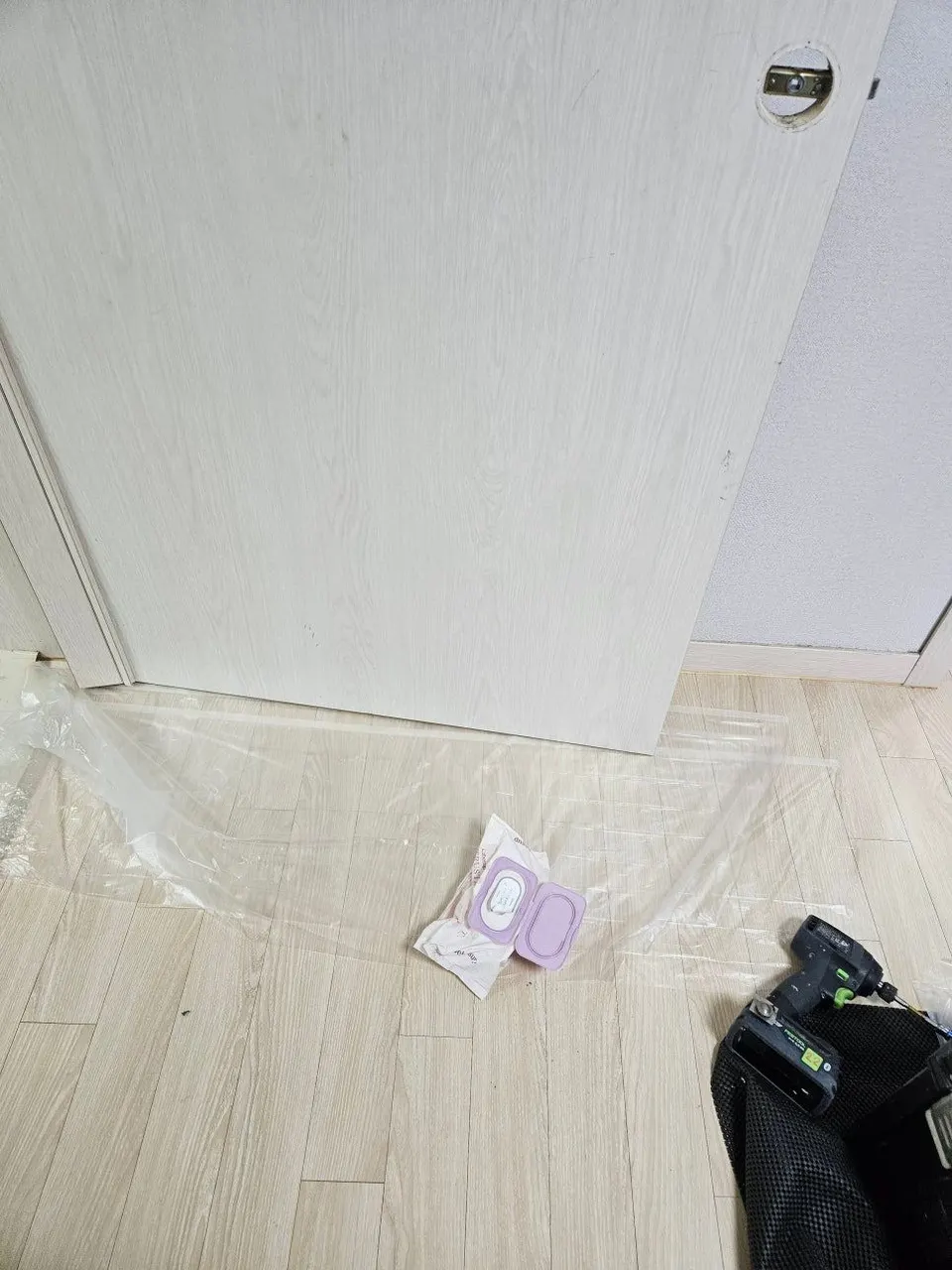 문 아래 바닥에 보양 비닐을 깔아 둔 작업 자리