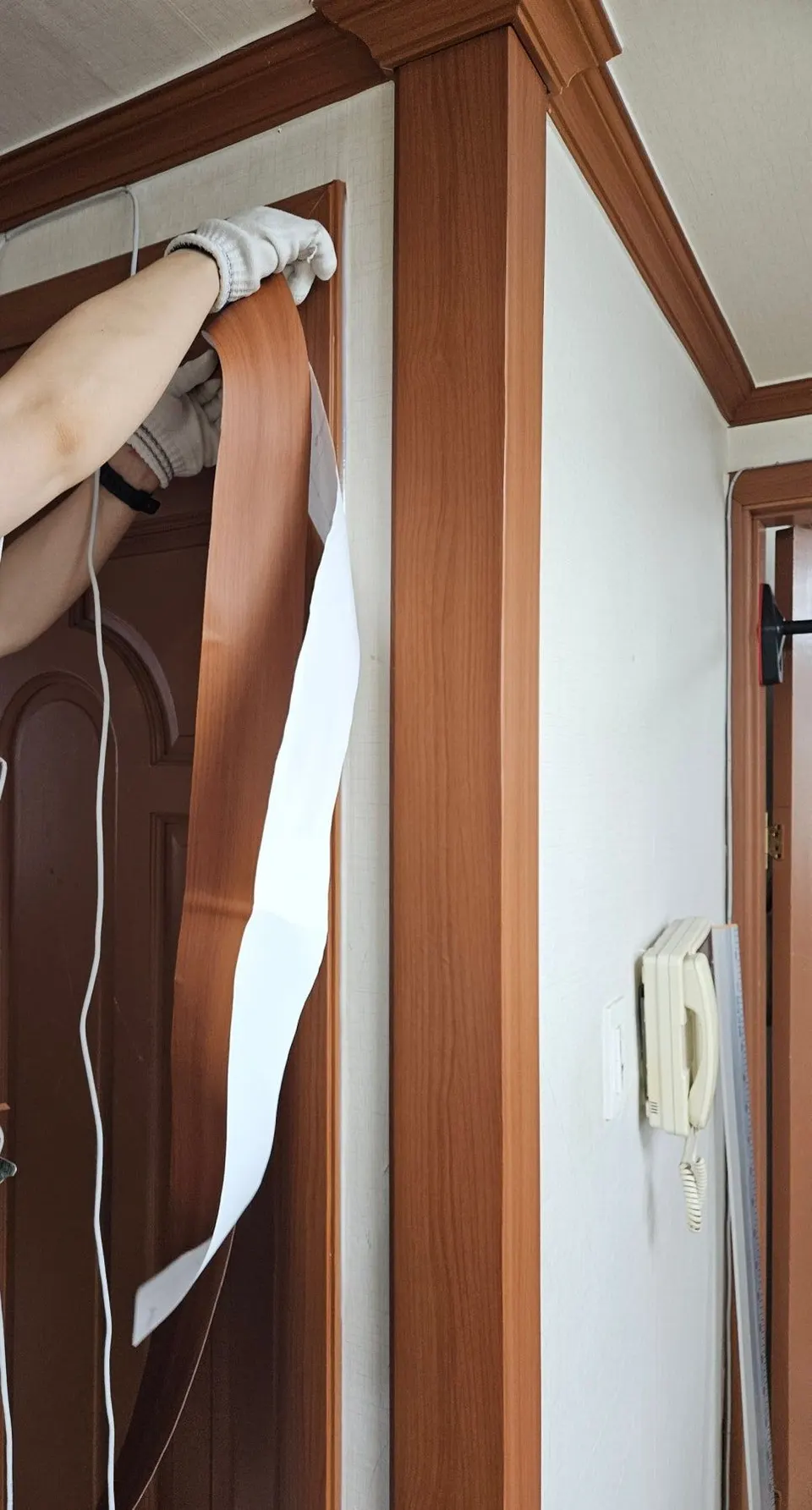 재단한 필름을 문틀 면에 맞춰 붙이는 모습