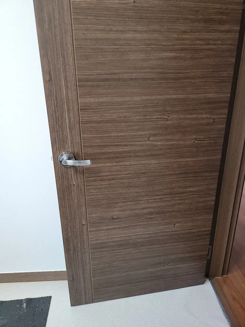 시트지 전면 시공 후 같은 문 — 구멍 자국 없이 가로 결이 이어진 복원 후 모습
