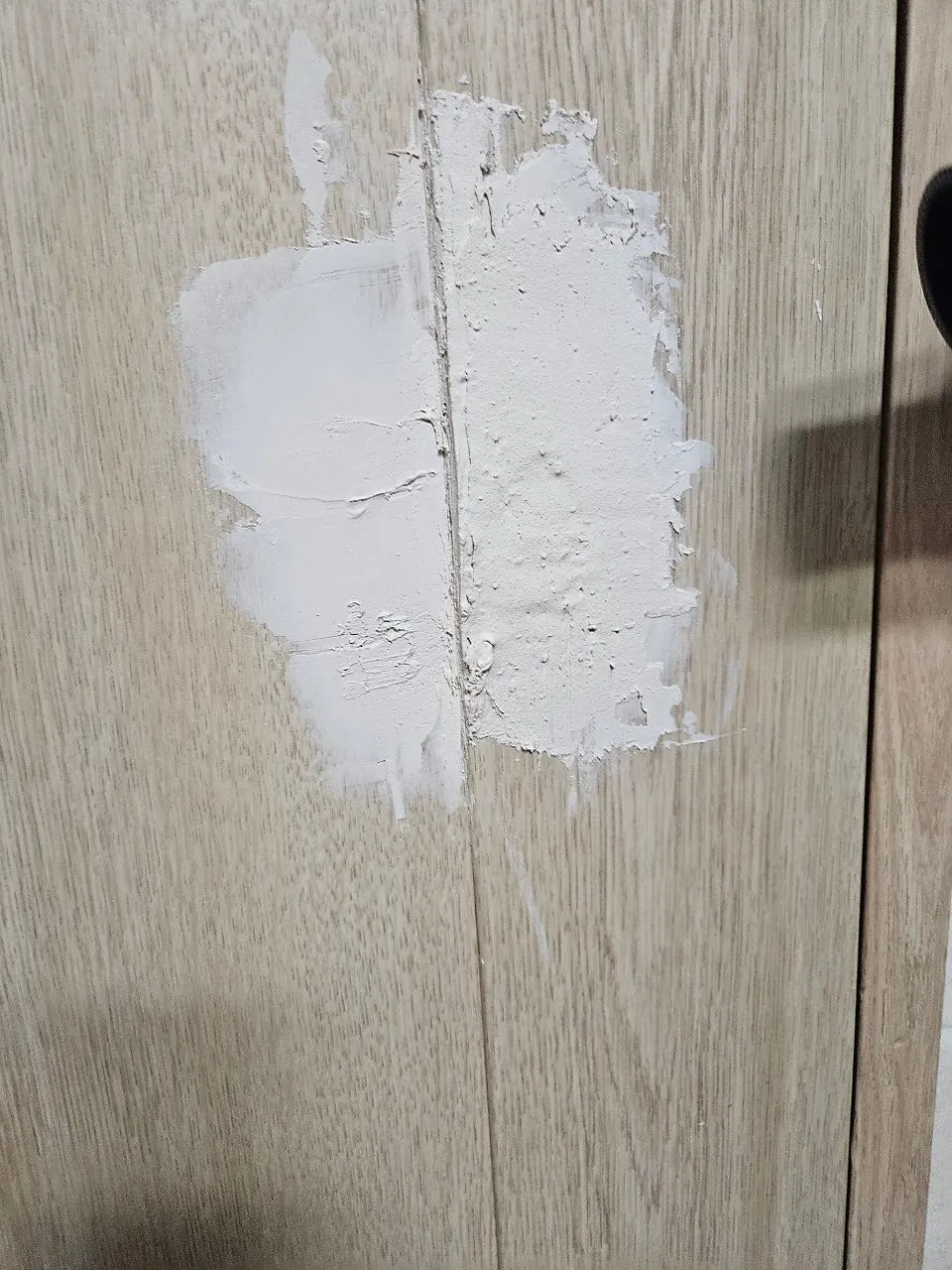 문 표면 깨진 자리에 두 줄로 퍼티를 펴 바른 모습