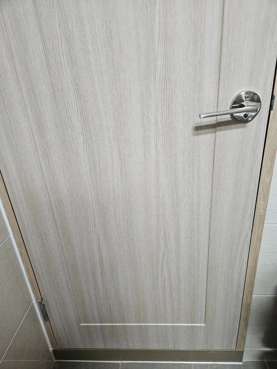 필름 시공 후 같은 문 — 손잡이 아래 깨짐 없이 매끈하게 이어진 모습