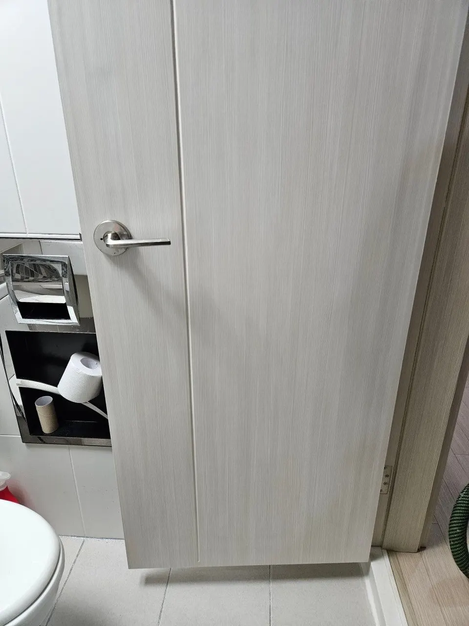 수리를 마친 화장실문 — 손잡이 아래 깨졌던 자리가 보이지 않는 모습