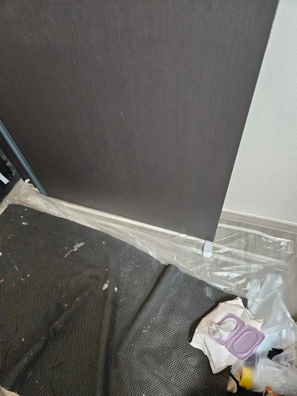 문 아래 바닥에 보양 시트를 깔아 둔 모습