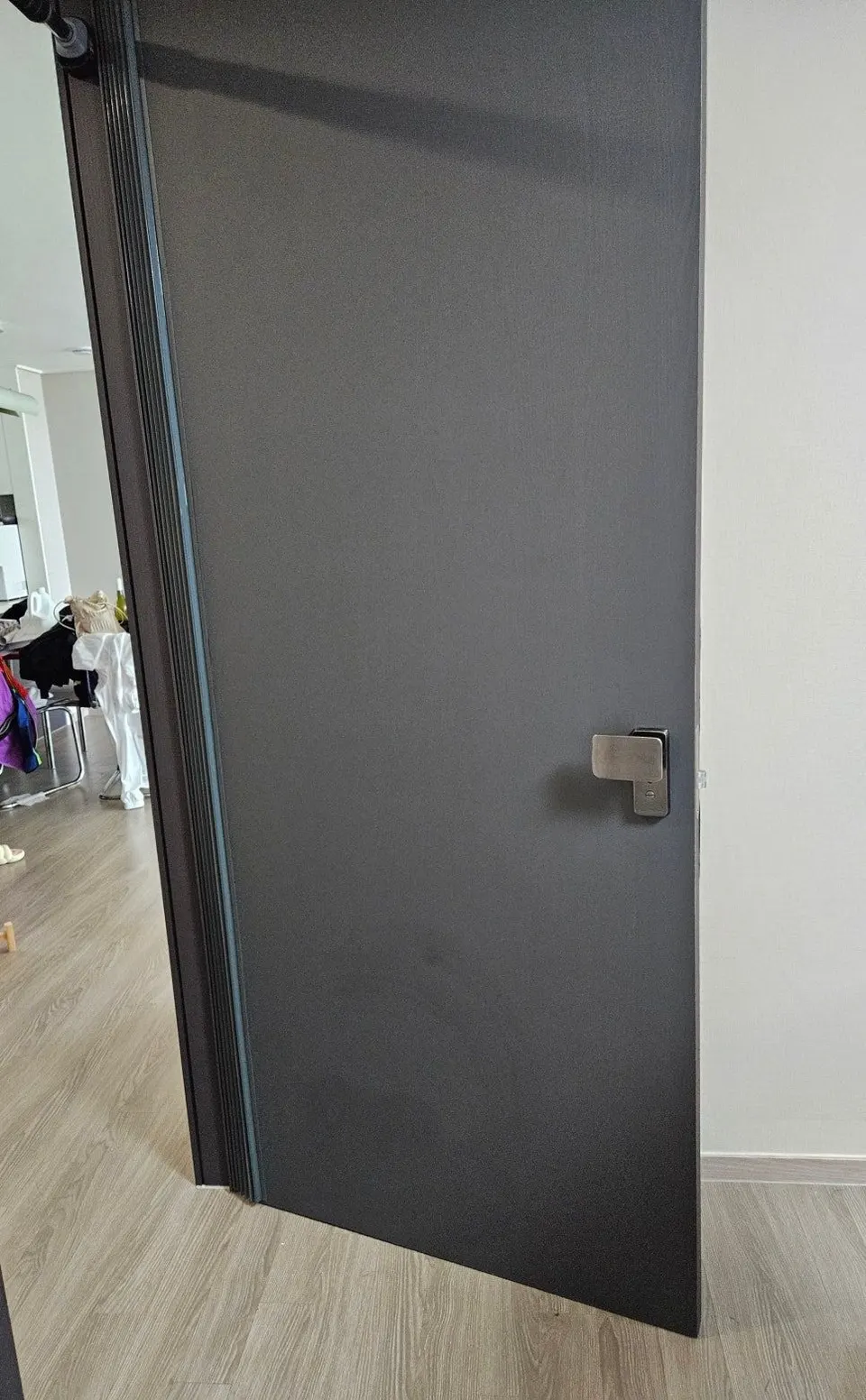 복원을 마친 짙은 회색 안방문 — 구멍 났던 자리가 보이지 않는 모습